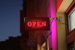 Bright red LED open mounted outside a business entrance at night