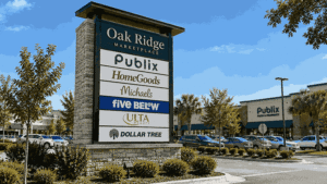 Large multi-tenant pylon sign with stone base showcasing retail tenant logos for Oak Ridge Marketplace shopping center